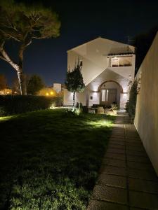 une maison éclairée dans la cour la nuit dans l'établissement La Villa apartments Tinaia - Excellent for Sardegna & Corsica - 6-8 beds - Private parking included with camera, à Livourne