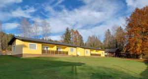 ein gelbes Haus mit einem großen Hof in der Unterkunft Ferienwohnung am See in Sankt Kanzian am Klopeiner See