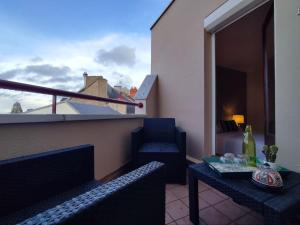 un balcone con un letto, un tavolo e delle sedie di LE DUPLEX DU MARCHÉ a Châteauroux