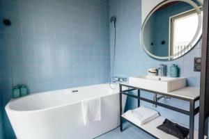 La salle de bains est pourvue d'une baignoire, d'un lavabo et d'un miroir. dans l'établissement JOST Hôtel Lille Centre, à Lille
