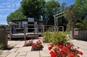 een tuin met een huis met bloemen ervoor bij Mobil Home XXL 4 chambres - Camping du Quinquis in Clohars-Carnoët