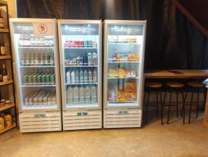 two refrigerators with drinks and a table in a room at Summit Flat Service in São José dos Campos
