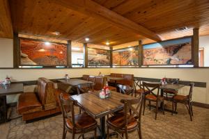 un ristorante con tavoli, sedie e quadri alle pareti di Thunderbird Lodge a Chinle