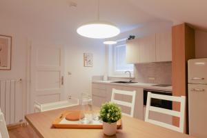 リュブリャナにあるLuxury 2 bedroom NEW apartment with private parkingの木製のテーブルのあるキッチンと白いキャビネットのあるキッチン +10枚の写真