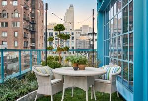 uma mesa e cadeiras numa varanda com vista para a cidade em Warren Street Hotel em Nova Iorque