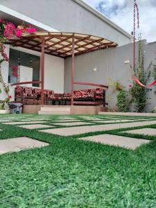 a building with a patio with red chairs and grass at فلل الكناري الراقية in Taif