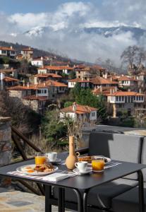 a table with food on it with a view of a city at Unedo All Seasons Hotel in Palaios Panteleimon