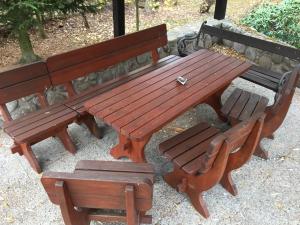 a wooden picnic table and two wooden benches at chata Alice in Rokytnice nad Jizerou