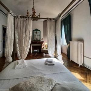 1 dormitorio con 1 cama con cortinas blancas y piano en Orfenor, en Brioude