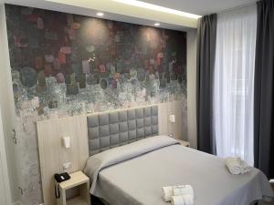 1 dormitorio con 2 camas y una pared de mosaico en Schilizzi Hotel en Nápoles