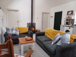 a living room with two couches and a table at Lavender lane cottage in Tralee