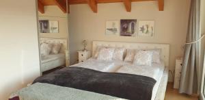 1 dormitorio con cama blanca y espejo en Ihre Auszeit am Golfplatz, en Meisdorf