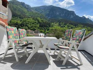 una mesa blanca y sillas en un balcón con montañas en Cosy house with roof terrace and stunning views, en Axat