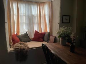 un sedile a finestra con cuscini su un davanzale con tavolo di Charming 2BR Cottage Retreat in the Centre of Bicester a Bicester