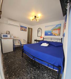 a bedroom with a blue bed and a kitchen at 4Seasons Suites Paradise Near Airport in Markopoulo