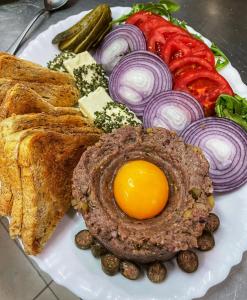 a plate of food with an egg and bread and vegetables at Altus Hotel & Spa in Praid
