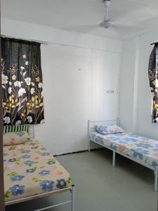 una camera con due letti e una finestra di Homestay Indrawasih a Perai