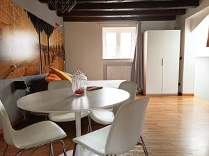 a dining room with a white table and chairs at Just Here apartments - La mansarda in Bari