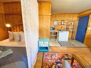 Habitación pequeña con cama y cocina en Flathead Lake Resort en Bigfork