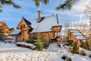drewniany domek na śniegu ze śniegiem w obiekcie Chata w chmurach Gliczarów w mieście Gliczarów Górny