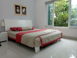 1 dormitorio con 1 cama con manta roja y ventana en Pham Gia Riverside Retreat, en Hà Nám