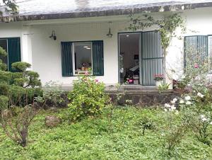 Casa blanca con ventana con persianas verdes en Pham Gia Riverside Retreat, en Hà Nám
