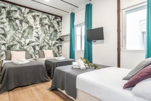 - 2 lits dans une chambre avec une fresque murale dans l'établissement BNBHolder Tropical CENTRE, à Madrid