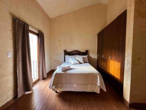 a bedroom with a bed and a large window at Villa Italiana, a 5min de Antigua in San Lorenzo El Cubo