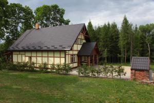 een huis met een zwart dak en een tuin bij Holiday Home Adam in Szymki