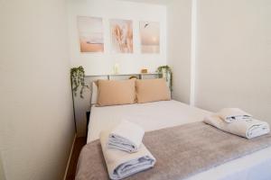 a small bedroom with a bed with towels on it at Torremolinos. Plaza de Andalucía Apartment in Torremolinos