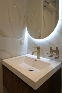 a bathroom with a sink and a mirror at Novallure Downtown - Short Stay Apartments in The Hague