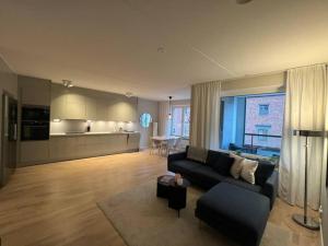 a living room with a couch and a kitchen at New apartment in Hagastaden in Stockholm