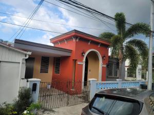 a red house with a car parked in front of it at Vadi's Lux, Wi-fi, coffe, tea, parking, laundry room. in Mayaguez