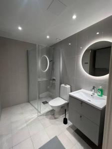 y baño con ducha, aseo y lavamanos. en New apartment in Hagastaden, en Estocolmo