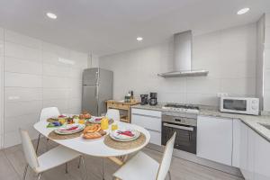 uma cozinha branca com uma mesa com comida em Laia House / Laia's house em Can Picafort