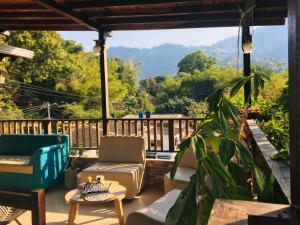 a porch with chairs and a view of the mountains at Hostal Los Wichos in Minca