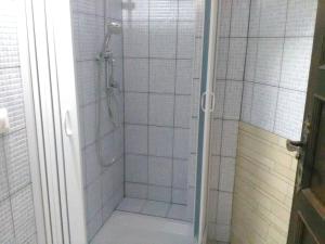 um chuveiro na casa de banho com azulejos brancos em One bedroom appartement with wifi at Bari Sardo 3 km away from the beach em Bari Sardo
