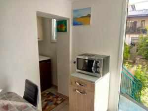 um quarto com um micro-ondas num armário com uma cadeira em One bedroom appartement with wifi at Bari Sardo 3 km away from the beach em Bari Sardo