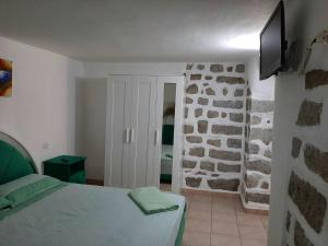 um quarto com uma cama e uma parede de pedra em One bedroom appartement with wifi at Bari Sardo 3 km away from the beach em Bari Sardo