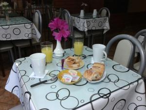 Hotel Colonial في بوينس آيرس: طاولة بيضاء عليها طعام افطار ومشروبات