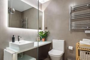 Un baño con inodoro, lavabo y espejo. en Apartamento da Foz, en Oporto 19 fotos más