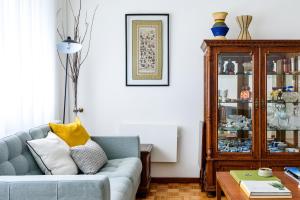 ein Wohnzimmer mit einem blauen Sofa und einem Holzschrank in der Unterkunft Apartamento da Foz in Porto