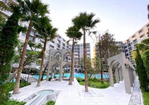 un patio con palmeras y una piscina en ชีวิตมีความสุข สะดวกสบาย ที่ลากาสิต้าC368, en Hua Hin