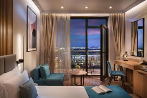 a hotel room with a bed and a desk and a window at Park & Spa Hotel Markovo in Plovdiv