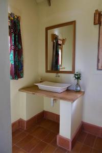 a bathroom with a sink and a mirror at Hyena Hill Lodge in Sanga
