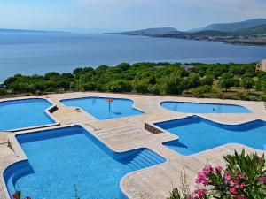 eine Gruppe von drei Pools mit Blick auf das Wasser in der Unterkunft Sunset Premium Camping in Klenovica