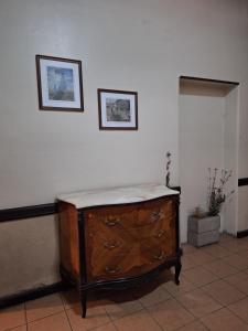 a wooden dresser in a room with two pictures on the wall at La posada del Colibrí in Mendoza