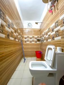 La salle de bains est pourvue de toilettes et d'un seau rouge. dans l'établissement Live Free Hostel Rishikesh, à Rishikesh