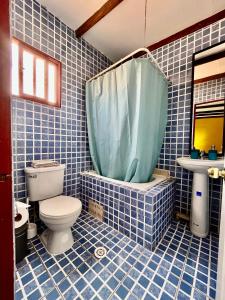 a blue tiled bathroom with a toilet and a sink at Hostal Qachi Chentura in San Pedro de Atacama