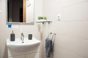 Baño blanco con lavabo y espejo en Residencia Universitaria Hernan Cortes en Salamanca